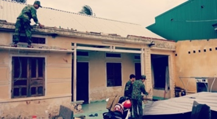 Lực lượng quân đội giúp dân lợp lại nhà sau khi bão tan