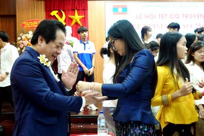 Các sinh viên Lào thực hiện nghi thức cột chỉ cầu may cho lãnh đạo tỉnh