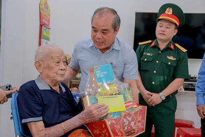 Phó Chủ tịch Thường trực UBND tỉnh Trần Hoàng Tuấn tặng quà ông Phan Công Chánh - Cựu chiến binh từng tham gia trận đánh làm nên Chiến thắng Ba Gia
